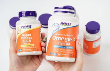 Dnipro, Ukrayna - 09.09.2023: Kadın elinde bir şişe Omega-3-6-9 vitamini. Şimdi Gıda, bir omega-3-6-9, Balık yağı. Vejetaryen gıda takviyeleri.