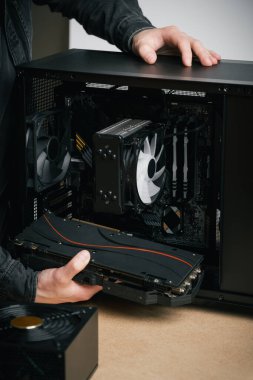 Bir bilgisayar teknisyeni bir bilgisayar güç kaynağı kuruyor. PC monte ediliyor
