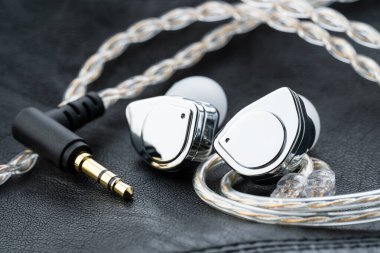 Tablo arka planındaki kulak monitöründe. Siyah plakalı özel kulak monitörleri. Bir müzisyenin konserde sahnede giymesi için özel kulaklık ya da el yapımı patlayıcılar..