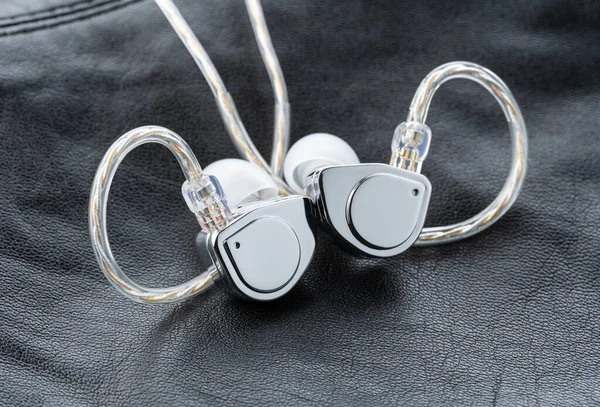 Tablo arka planındaki kulak monitöründe. Siyah plakalı özel kulak monitörleri. Bir müzisyenin konserde sahnede giymesi için özel kulaklık ya da el yapımı patlayıcılar..