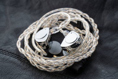 Tablo arka planındaki kulak monitöründe. Siyah plakalı özel kulak monitörleri. Bir müzisyenin konserde sahnede giymesi için özel kulaklık ya da el yapımı patlayıcılar..