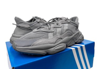 Dnipro, Ukrayna - 05.08.2024: Arka planda izole edilmiş gri adidas spor ayakkabılarına yakın görüş. Gri Adidas Sneakers ve Kutu Saydam Kaydırma Çekimi Mağaza Masasında.