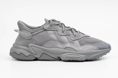 Dnipro, Ukrayna - 05.08.2024: Arka planda izole edilmiş gri adidas spor ayakkabılarına yakın görüş. Gri Adidas Sneakers ve Kutu Saydam Kaydırma Çekimi Mağaza Masasında.