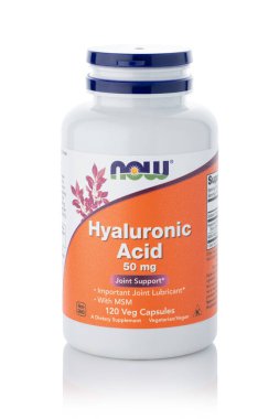 Dnipro, Ukrayna -09.09.2023: Bir şişe Hyaluronic Asit kadın elinde. Şimdi Gıda, Hyaluronic Asit 50 mg. 120 sebze kapsülü. Vejetaryen gıda takviyeleri.