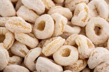 Tatlı mısır halkaları. Beyaz arka planda beyaz mısır gevreği yığınına izole edilmiş lezzetli mısır gevreği halkaları, lezzetli ve kullanışlı halkalar kahvaltı gevreği. Kahvaltı gevreği tatlı halkaları beyaza izole edilmiş