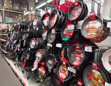 Dnipro, Ukrayna - 26.07.2024: Ev eşyaları mağazasında mutfak gereçleri. Evdeki mutfakta yemek pişirmek için yemek takımı almak. Çeşitli kızartma tavaları, tencereler, raflarda satılık aletler.