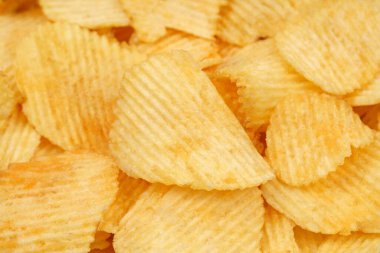 Makroda dönen çıtır patates cipsi. Kızarmış patatesler yakın mesafede. Sağlıksız fast food için patates çerezi.