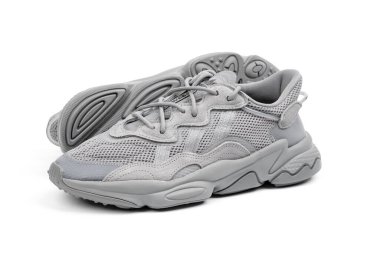 Dnipro, Ukrayna - 05.08.2024: Arka planda izole edilmiş gri adidas spor ayakkabılarına yakın görüş. Gri Adidas Sneakers ve Kutu Saydam Kaydırma Çekimi Mağaza Masasında.