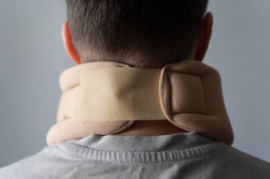 Servikal yakalı genç bir adamın portresi. Servikal omurga esnemesi ve terapi konsepti. Yetişkin adam ortopedik tasma takıyor. Omurga yaralanması. Boyun hastalıkları tedavisi. Tıbbi tasma. Rehabilitasyon