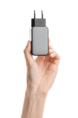 Beyaz arkaplanda siyah telefon AC şarj aleti ve USB kablosu.