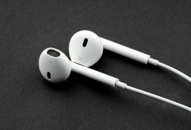 Dnipro, UKRAINE 29.04.2025: Beyaz arka planda izole edilmiş elma kulaklıkları. Yeni kablolu kulaklıklar Apple Earpod 'lar yeni aygıt Apple Bilgisayarlar paketleri açıyor. iPhone Apple Kulaklıkları
