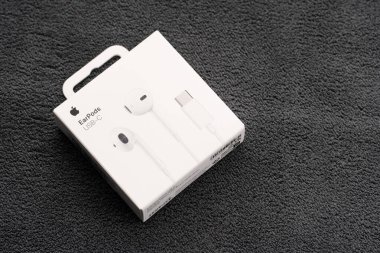 Dnipro, UKRAINE 29.04.2025: Beyaz arka planda izole edilmiş elma kulaklıkları. Yeni kablolu kulaklıklar Apple Earpod 'lar yeni aygıt Apple Bilgisayarlar paketleri açıyor. iPhone Apple Kulaklıkları