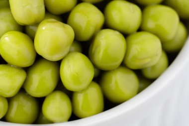 Taze bezelye arkaplanı, arka plan olarak mükemmel soyulmuş bezelye tanelerinin dokusu. Sebze, sebze proteini, sağlıklı ürünler. Konserve bezelye..