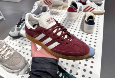 Dnipro, Ukrayna - 11.05.2025: Adidas Spezial spor ayakkabılarına yakın çekim. Bir adam spor ayakkabılarını Adidas mağazasının penceresinin yanında tutuyor. Spor ve günlük ayakkabılar..