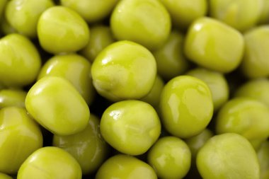 Taze bezelye arkaplanı, arka plan olarak mükemmel soyulmuş bezelye tanelerinin dokusu. Sebze, sebze proteini, sağlıklı ürünler. Bezelye konservesi. bir çember içinde dönüyor