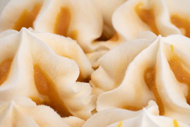 Beyaz arka planda izole edilmiş vanilyalı ve karamelli dondurmalı plastik kap. Küvette dondurulmuş tatlı, kremalı doku..