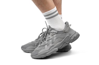 Dnipro, Ukrayna - 05.08.2024: Arka planda izole edilmiş gri adidas spor ayakkabılarına yakın görüş. Gri Adidas Sneakers ve Kutu Saydam Kaydırma Çekimi Mağaza Masasında.