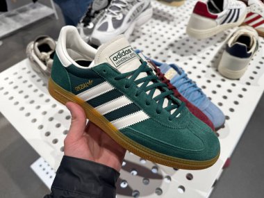 Dnipro, Ukrayna - 11.05.2025: Adidas Spezial spor ayakkabılarına yakın çekim. Bir adam spor ayakkabılarını Adidas mağazasının penceresinin yanında tutuyor. Spor ve günlük ayakkabılar..