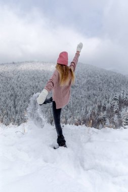 Back view of a young woman playing with snow Outdoor Winter Lifestyle happiness emotions nature on background