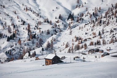 Karla kaplı güzel dağlar ve ahşap evler. 