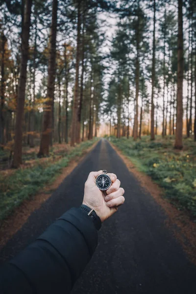 stock image Traveler man searching direction with a compass in a forest. Point of view shot