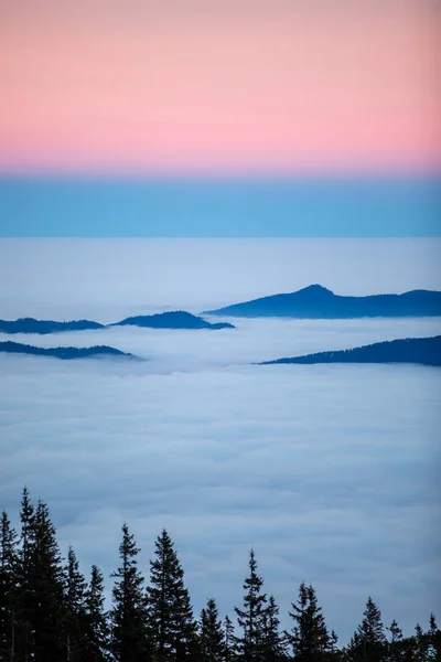 stock image beautiful pink sunrise in mountains covered with snow and clouds