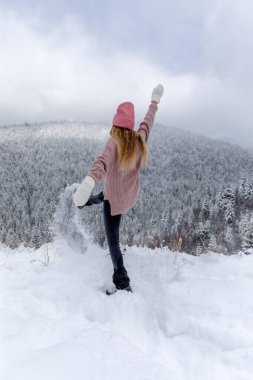 Back view of a young woman playing with snow Outdoor Winter Lifestyle happiness emotions nature on background