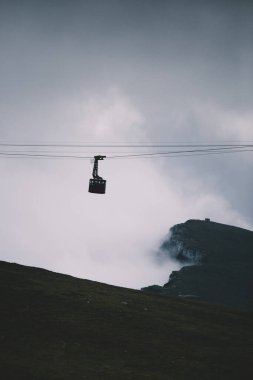 Cableway over the foggy valley in the mountains