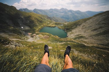 legs of a man on a mountain lake background 
