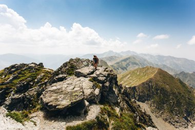 Young woman backpacker walking on a pathway in the mountains