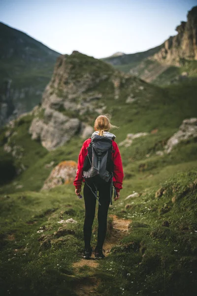 Woman backpacker standing on a pathway in the mountains