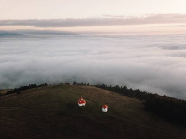 Romano Catholic chapel at Perko Sanzieni village, Covasna county Romania, Transylvania. Captured from above with drone at sunrise  clipart