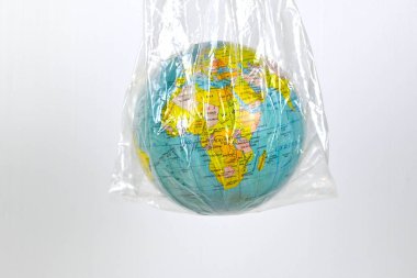 Dünya atlası beyaz zemin üzerinde plastik torba içinde, kopyalama alanı, çevre dostu, dünyayı kurtar, plastik torba yok, kirlilik konsepti atık tasarrufu çevreyi sürdürülebilir kavramı azaltır