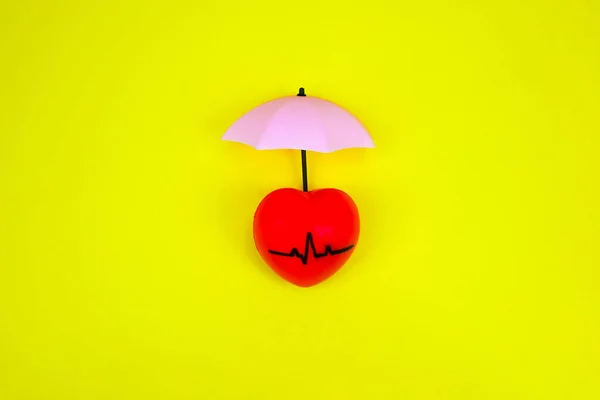 Pulsing heart, heartbeat with umbrella cover above symbolise as preventing and protection Coronary Heart Diseases, heart illness problems and risks, healthy heart concern and awareness. Healthy heart