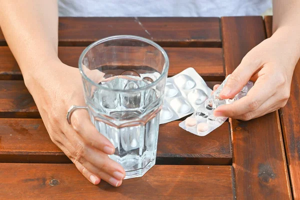 Hand hold glass of water and pharmaceutical pane. Healthcare medical concept.