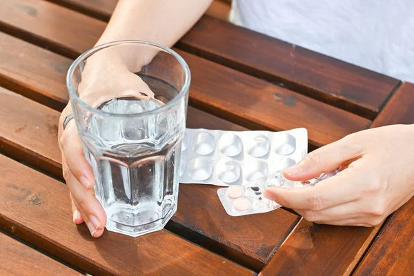 Hand hold glass of water and pharmaceutical pane. Healthcare medical concept.