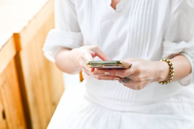 Close-up image of female hands using smartphone, working online., shopping, searching or social networks concept, hipster lady typing an sms message to her friends.