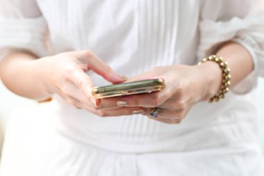 Close-up image of female hands using smartphone, working online., shopping, searching or social networks concept, hipster lady typing an sms message to her friends.