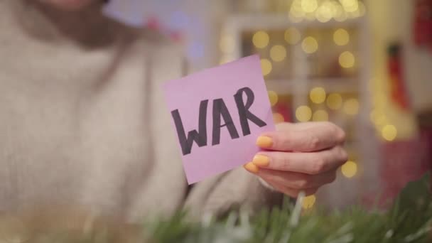 女性はクリスマスの背景を持つ単語戦争とシートを燃やす 戦争中の精神的な問題や精神的なケアについてのビデオ 高品質の4K映像 — ストック動画