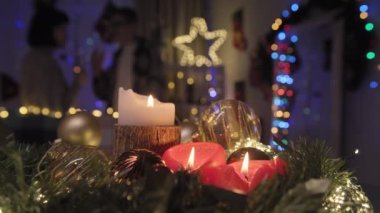 In the foreground are Christmas decorations. In the background, a couple communicates and drinks champagne. High quality 4k footage