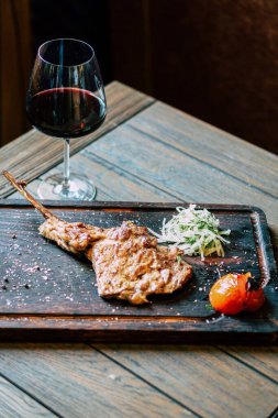 Sebzeli biftek ve ahşap masada baharat.