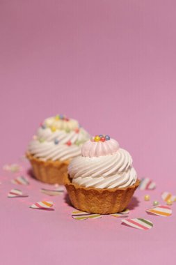 a closeup shot of a delicious cupcake with a pink sprinkles on a white background