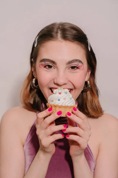 stock image young woman with a cake near her face