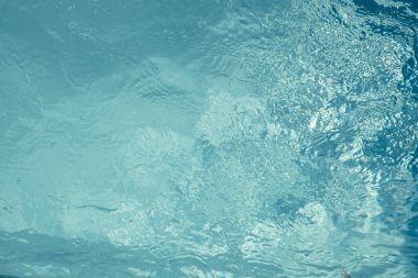 Bulanık mavi, berrak, durgun su yüzeyi dokusu sıçrama ve kabarcıklarla kaplı. Moda soyut doğa geçmişi. Güneş ışığında su dalgaları. su arkaplanı