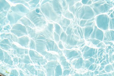 Bulanık mavi, berrak, durgun su yüzeyi dokusu sıçrama ve kabarcıklarla kaplı. Moda soyut doğa geçmişi. Güneş ışığında su dalgaları. su arkaplanı