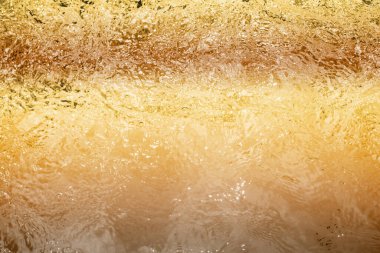 Blurred transparent Yellow Gold colour clear calm water surface texture with splashes and bubbles. Trendy abstract nature background. Water waves in sunlight. water background, oil