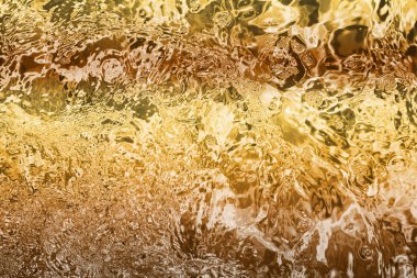Blurred transparent Yellow Gold colour clear calm water surface texture with splashes and bubbles. Trendy abstract nature background. Water waves in sunlight. water background, oil