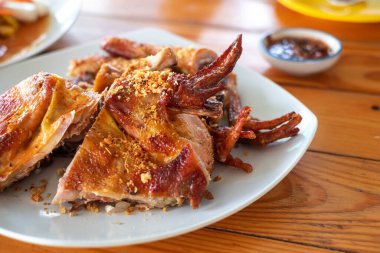 Beyaz tabakta kızarmış tavuk Tayland 'ın yerel bir yiyeceğidir. Her bölgede bulunur. Mümkün olduğunca papaya salatasıyla yiyin..