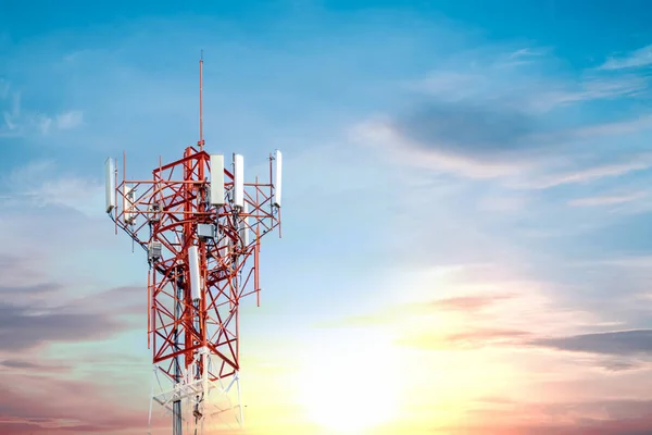Gökyüzünde bir sürü sinyali olan kırmızı telefon kulesi ve akşamları çekilen beyaz bulutlar. Güneş ufuktan aşağı iniyor.