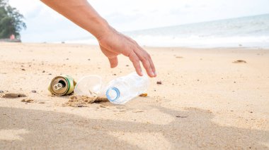 Plajda plastik şişe temizliği yapan bir el. Dünya konseptini kurtar. Çevre, ekoloji bakımı, yenilenebilir konsept, doğa koruma turizmi